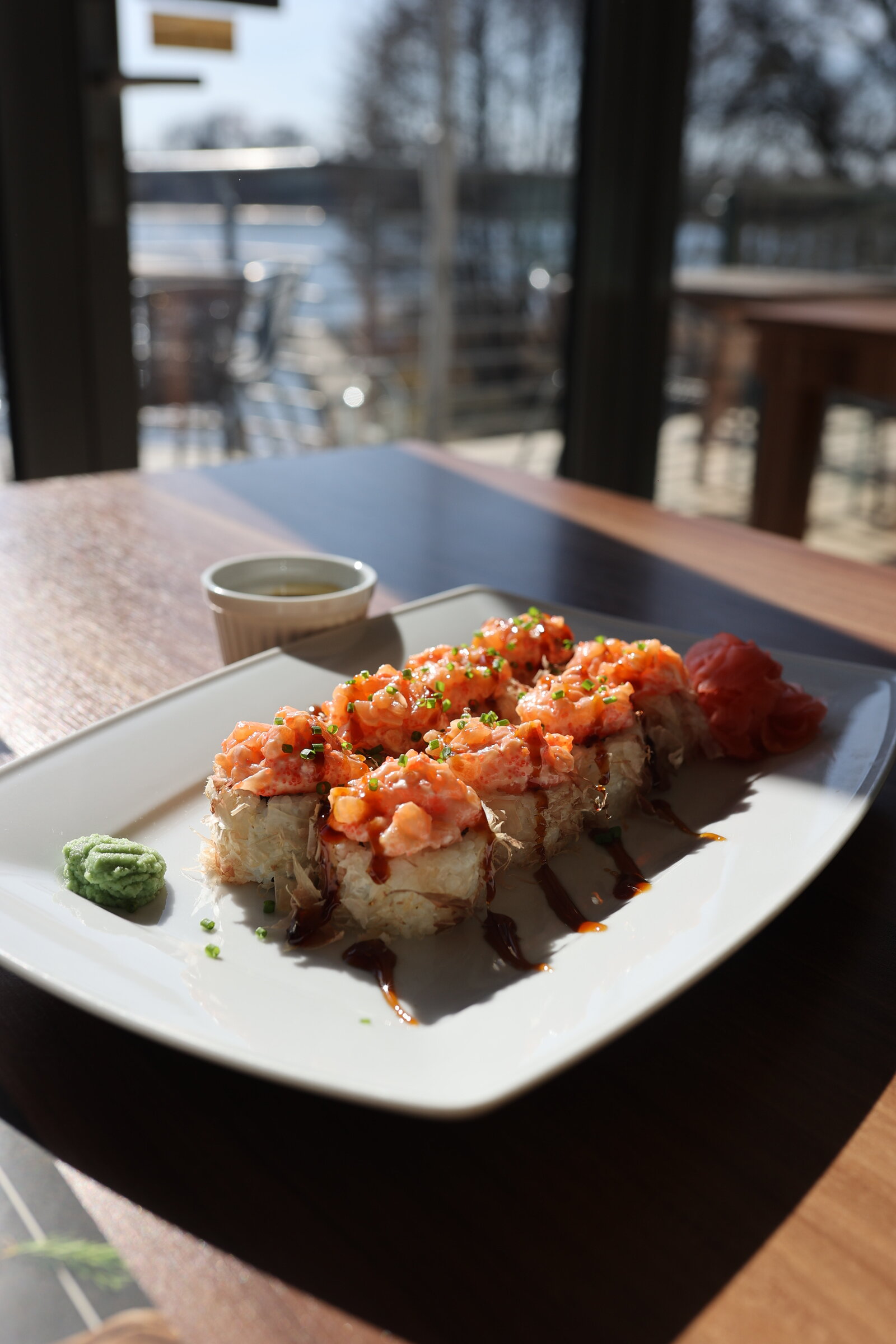 Talerz sushi przy oknie z widokiem na jezioro